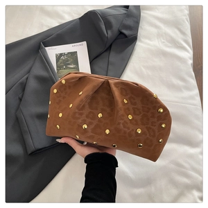 Close-up of brown leopard print clutch with gold studs and pleated cloud design