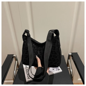 Détail d'un sac cabas noir chic à motif léopard avec de larges bandoulières tissées