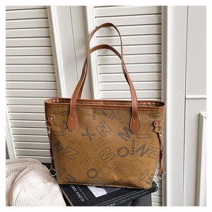 Détail d'un sac cabas vintage marron avec imprimé monogramme sur un livre de mode