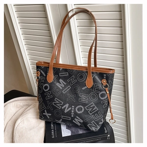 Détail d'un grand sac cabas avec imprimés lettres et poignées en cuir marron