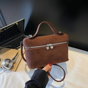 Sac boîte vintage en daim marron avec fermeture cœur dans un décor de bureau chic