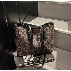 Detail shot of leopard print tote bag with durable canvas texture and black leather straps