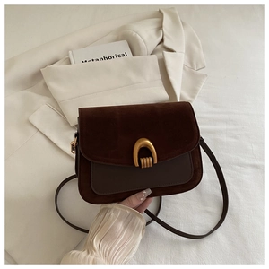 Detail view of dark brown leather handbag featuring a vintage gold U-shaped metal buckle lock