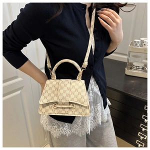 Detail of monogram M print bag with gold hardware and removable shoulder strap
