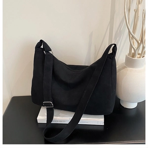 Détail d'un grand sac hobo en nylon noir avec bandoulière réglable et boucle en argent