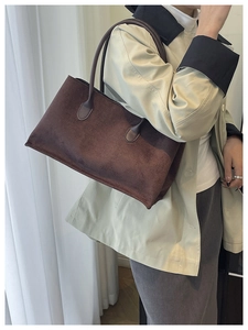 Detail view of the deep brown faux suede shoulder bag with fine matte texture and stitching