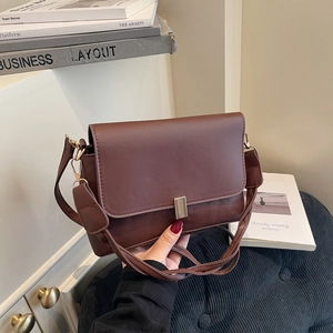 Vintage dark brown leather crossbody bag with a minimalist gold buckle on the front flap