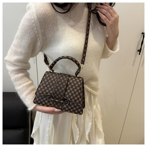 Detail of vintage monogrammed brown leather handbag with gold buckle and hardware details