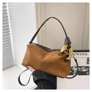 Gros plan sur le sac en daim caramel avec grosse chaîne dorée et détails en cuir