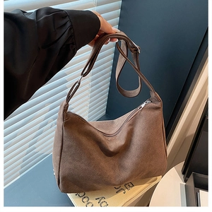Détail du sac bandoulière en daim marron café avec fermeture éclair et sangle réglable