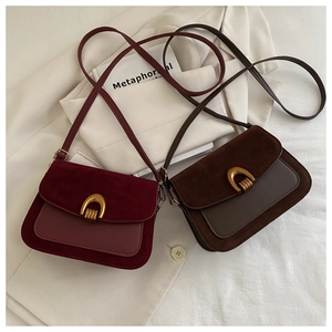 Detail of vintage patchwork crossbody bags with gold horseshoe buckles in burgundy and coffee