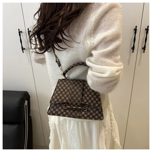 Detail shot of vintage brown monogram shoulder bag with stylish crossbody strap and hardware