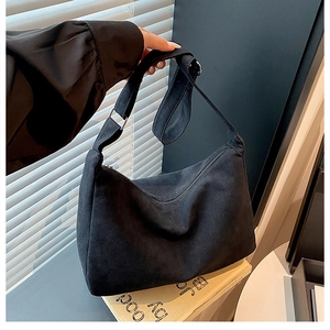 Détail de la bandoulière réglable et boucle en métal argenté sur un sac hobo noir chic