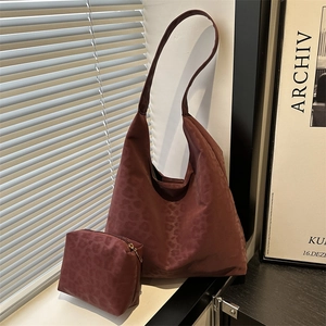 Deep brown leopard print tote bag with matching pouch in natural light setting