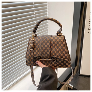 Detailed view of brown vintage monogram bag with golden lock and adjustable strap