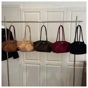 Detailed row of vintage suede bucket bags in caramel, beige, coffee, burgundy and black