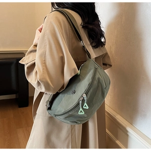 Detail shot of army green crescent nylon bag with triangular zipper pull and logo