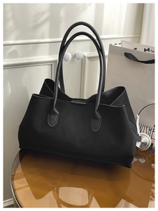 Detail view of large black matte tote bag showing the smooth texture and slim handles