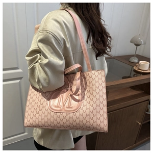 Close-up of pink tote bag featuring repeating M-pattern and large embossed logo