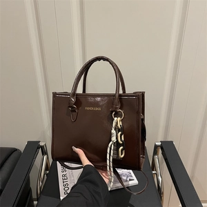 Dark brown faux leather tote bag with glossy finish and detachable shoulder strap