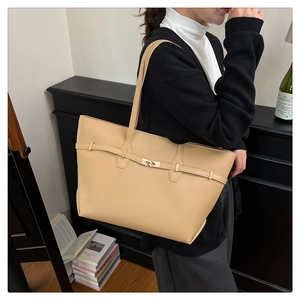 Detail of minimalist beige tote bag with a golden buckle closure for office commute