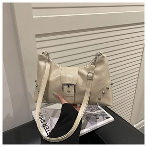 Détail du sac à bandoulière beige vintage avec rivets argentés et large sangle à boucle