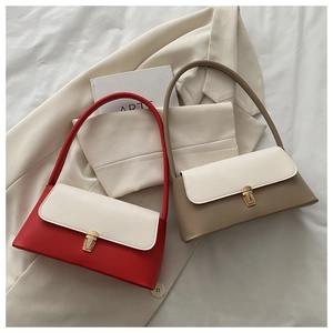 Detail view of contrast color shoulder bags with elegant metal buckles on white blazer