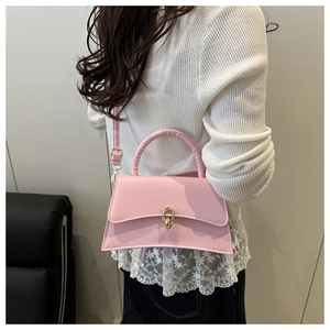 Détail du sac à main trapèze rose avec fermoir anneau doré et bandoulière réglable pratique