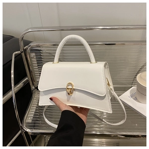 Sac à main trapèze blanc élégant avec boucle dorée présenté dans un cadre de style de vie