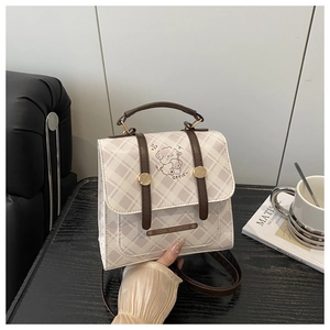 Détail du petit sac à dos à carreaux avec motif ours mignon et boucle dorée vintage