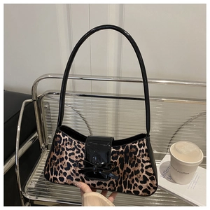 Gros plan du sac baguette léopard avec un nœud noir élégant sur le rabat en vernis