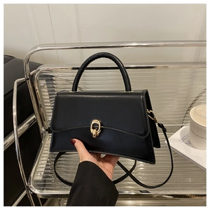 Gros plan détaillé d'un sac à main en cuir noir avec un fermoir à boucle dorée