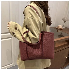 Deep burgundy leopard print tote bag shown on shoulder for daily commute style