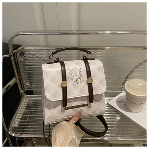 Détail du sac à dos à carreaux violets avec imprimé chien sur une chaise en métal