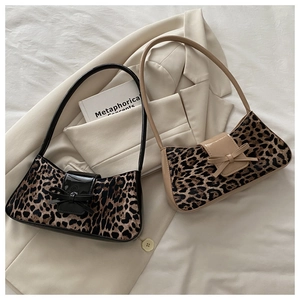 Détail de sacs baguette léopard avec nœuds brillants sur une veste beige chic
