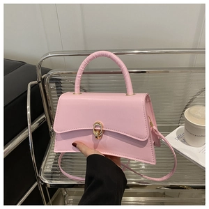 Détail du sac trapèze rose clair avec fermoir doré et cuir à texture délicate