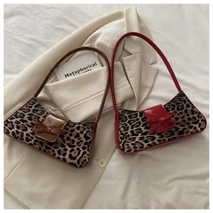 Détail de sacs léopard avec rabats en cuir brillant et décoration de nœud élégant