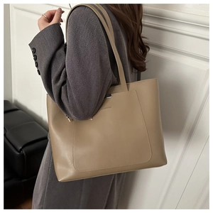 Gros plan sur un grand sac cabas kaki en cuir avec foulard en soie et bordure métal