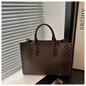 Détails de l'imprimé vintage M et des finitions métalliques dorées sur le sac cabas