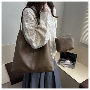 Detail of a large brown vintage tote bag with matching zippered pouch and natural texture