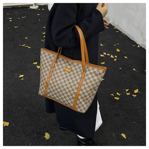 Outdoor street style shot of a woman carrying a patterned large capacity tote bag