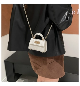 Detail of white crocodile texture mini bag with gold chain and metal turn-lock closure