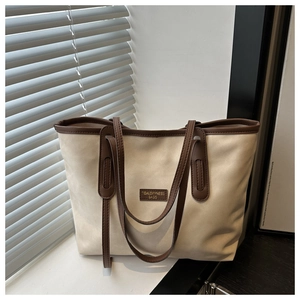 Detail of canvas tote bag featuring leather handles and TIDALDRYNESS brand label