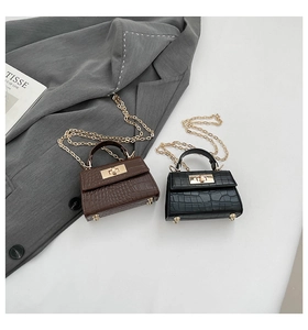 Close-up of crocodile pattern leather mini bags with gold turn-lock and chain straps
