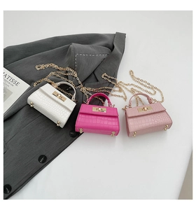 Detailed view of crocodile pattern mini handbags with golden hardware and chain strap