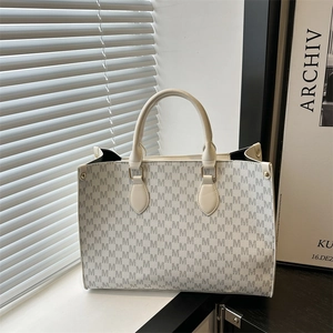 Minimalist white tote bag with all-over M monogram pattern and gold metal hardware