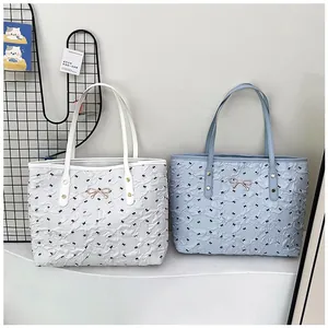 Détail du sac cabas plissé avec motifs nœuds noirs et ornements dorés élégants
