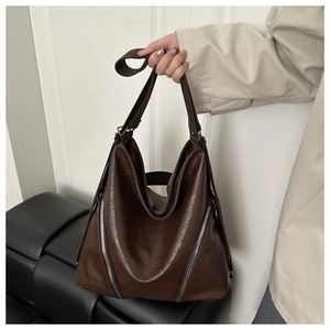 Détail du grand sac cabas en cuir marron foncé avec texture froissée et fermetures argentées
