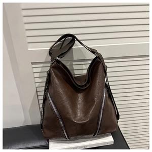 Détail du sac en similicuir marron avec fermetures éclair métalliques argentées parallèles