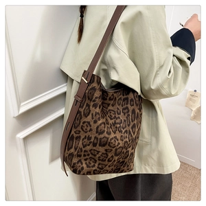 Macro shot of leopard print suede shoulder bag with adjustable leather strap and metal buckle